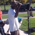 A man taking a picture of something on the street.