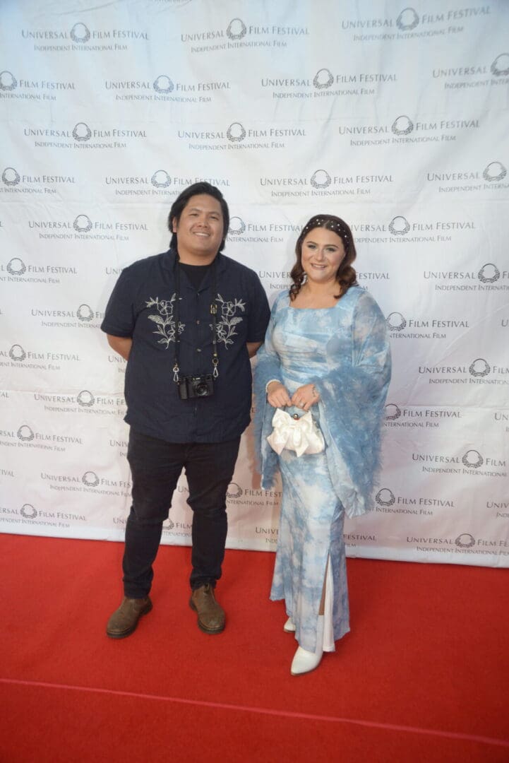 A man and woman posing for the camera on a red carpet.